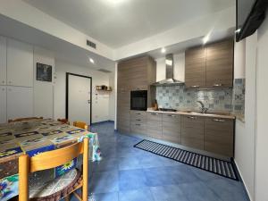 a kitchen with wooden cabinets and a table and a sink at Casa Vacanze Capo Vaticano in Ricadi