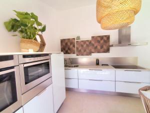 a kitchen with white cabinets and a stove at Villa MOOJŸ in Carcès