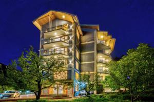 ein hohes Gebäude mit Bäumen davor in der Unterkunft MRPS Eco Eden Resort nd Spa manali in Manali