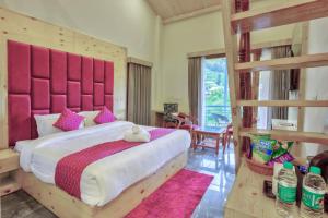 Schlafzimmer mit einem großen Bett mit einem rosa Kopfteil in der Unterkunft MRPS Eco Eden Resort nd Spa manali in Manali + 37 Fotos