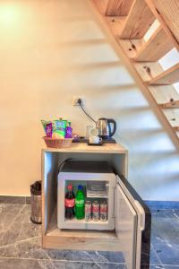 ein kleiner Kühlschrank mit Getränken darin unter einer Treppe in der Unterkunft MRPS Eco Eden Resort nd Spa manali in Manali