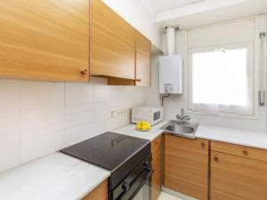 eine Küche mit Holzschränken und einer Spüle in der Unterkunft Apartment Port Salanca by Interhome in Llança