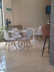 a group of tables and chairs in a room at A Oasis Taveta in Taveta
