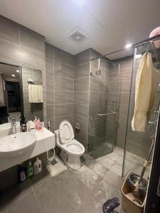 a bathroom with a toilet and a sink and a shower at Happy Home in Ha Long