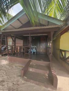 a porch of a house with a table and chairs at Rainbow Tioman Cottage in Kampong Juara