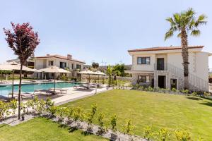a house with a large yard with a swimming pool at Mara Bahçe Alaçatı in Çeşme