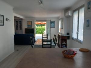 a living room with a couch and a table and chairs at Maison à 100m de la plage in La Turballe