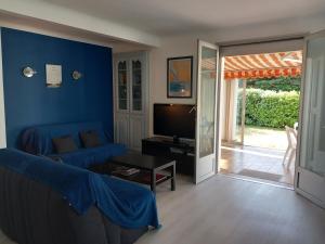 a living room with a couch and a tv at Maison à 100m de la plage in La Turballe
