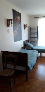 a room with two beds and a chair at La Couleur des Temps in Couiza