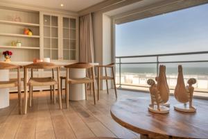 a living room with a table and a large window at 1e Verdiep appartement op de zeedijk in Knokke met 3 slaapkamers voor max 7 pers in Knokke-Heist +25 photos