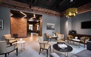 a waiting room with chairs and tables and a tv at CITYHOTEL Residence in Kyiv