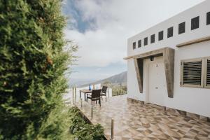 un patio con tavolo e sedie su un edificio di La Golosa, finca espectacular a los pies de El Teide donde encontrarás Lujo, Relax y Naturaleza a La Orotava