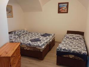 two twin beds in a room with a wooden dresser at Chalupa u Jirky in Staré Ransko