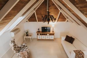un soggiorno mansardato con un divano bianco e un lampadario di La Golosa, finca espectacular a los pies de El Teide donde encontrarás Lujo, Relax y Naturaleza a La Orotava