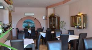 a dining room with tables and chairs in a restaurant at Garfild Guest house in Novi Vinodolski
