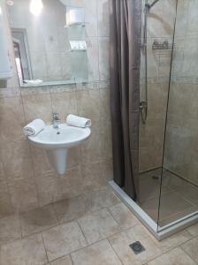 a bathroom with a sink and a shower at Fotiadis - Cosy apartments and spectacular rooms in Veliko Tŭrnovo +65 photos