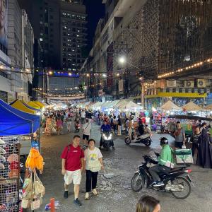 een groep mensen die 's nachts over een straatmarkt loopt bij Hotel Soni Mansion Pratunam in Bangkok +69 foto's