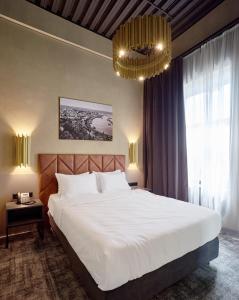a bedroom with a large white bed and a chandelier at CITYHOTEL Residence in Kyiv
