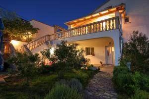 een wit huis met een balkon en een trap bij Apartments Tomas in Senj