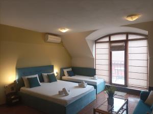 a bedroom with two beds and a window at Fotiadis - Cosy apartments and spectacular rooms in Veliko Tŭrnovo