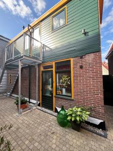 a house with a balcony on top of it at Hotel West Inn Aan Zee in Den Oever