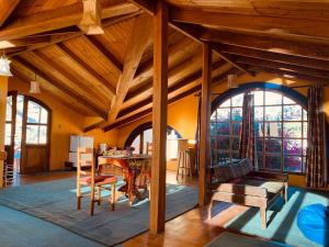 a living room with wooden ceilings and a table and chairs at Jardines de Gaia in La Paz
