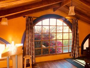 a room with a large window and a table and stool at Jardines de Gaia in La Paz