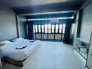 a bedroom with a large bed and a window at Lamoon Thungsao in Sathani Khlong Rian +6 photos