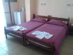 a bedroom with a bed with two towels on it at Christina Pension in Karterados