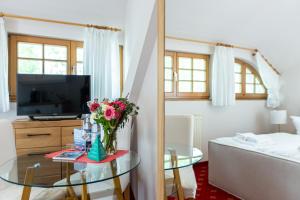a living room with a tv and a table with flowers at Strandhaus Claassen 07 in Ahrenshoop