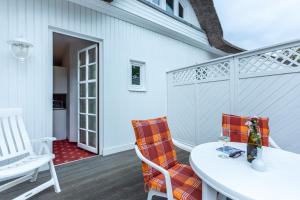 a patio with a table and chairs and a door at Strandhaus Claassen 07 in Ahrenshoop