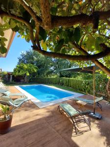 una piscina con due sedie e un ombrellone di As Pagonas a Moaña