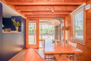 a dining room with a wooden table and chairs at Liiiving in Ofir - Seaside Pool Bungalow in Fão