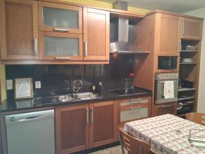 a kitchen with wooden cabinets and a sink and a table at Praia Espinho in Espinho