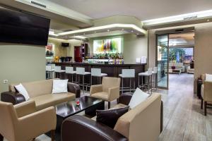 a bar in a hotel lobby with leather furniture and a bar at Garden in Limenaria