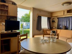 a living room with a table and a tv at ZP 360 - Camping de Zandput in Vrouwenpolder