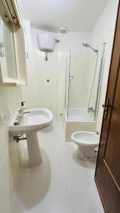 a white bathroom with a sink and a toilet at Ampio Appartamento su 2 Livelli nel Centro Storico, Ideale per Coppie o Gruppi da 2 a 5 Persone in Fiuggi +22 photos