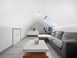 a living room with a couch and a table at Pass the Keys Spacious Garden Family House - Marks Gate in Romford