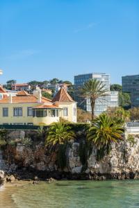 a house on a cliff next to the water at Bolina 2 Historic Center Cascais in Cascais