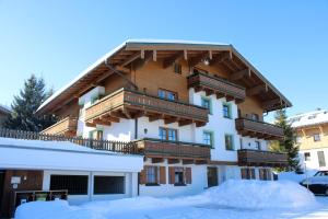 ein Gebäude mit Balkonen darüber im Schnee in der Unterkunft Chalet Alpine Royal A Top 1 in Krimml