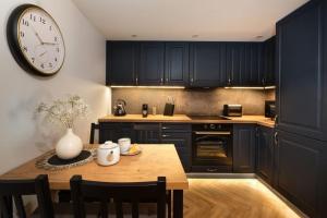 a kitchen with a table and a clock on the wall at Westminster Apartments in Kudowa-Zdrój +15 photos