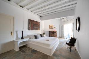 une chambre blanche avec un grand lit et une chaise dans l'établissement Villa Ipanema with Private Beach by Mykonos Mood, à Mykonos 39 autres photos