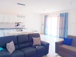 a living room with a blue couch and a kitchen at Da Faby e Marcy in Settimo San Pietro