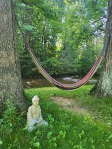 aitatingitating woman sitting in the grass next to a hammock at Godspeed Events and Lodging in Port Matilda
