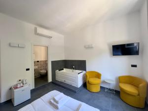 a bathroom with a bed and a sink and yellow chairs at Da Zoe suite fontanavecchia in Vernazza