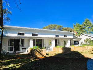 a large white house with a porch at Anamcara Villa 3, Natal Midlands Balgowan in Balgowan