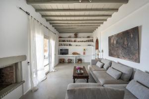 un salon avec un canapé et une cheminée dans l'établissement Villa Ipanema with Private Beach by Mykonos Mood, à Mykonos