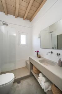 une salle de bain blanche avec un lavabo et des toilettes dans l'établissement Villa Ipanema with Private Beach by Mykonos Mood, à Mykonos