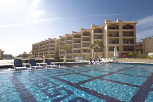 a swimming pool with chairs and a hotel at Selena Bay Hotel Suites in Hurghada