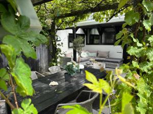 une terrasse en bois avec un canapé et des chaises. dans l'établissement Lichtdurchflutetes Traumhaus 800 Meter zum Strandaufgang, uneinsehbarer Garten mit Terrassenüberdachung, hundefreundlich, à Sint Maartenszee
